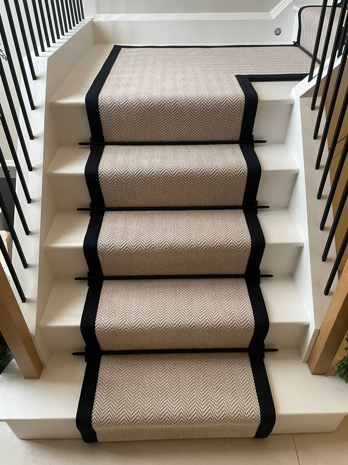 Light herringbone stair runner finished with contrasting black tape binding